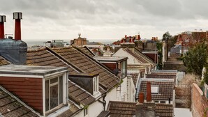 A residential area with terraced houses, a sea view, and a large industrial chimney. - Sea view, pet friendly central Laines location, 1 minute from station  (Brighton)