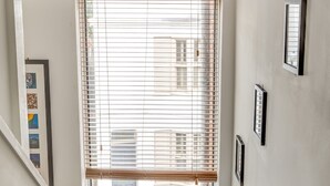 A staircase with a window at the top, a small potted plant, and framed pictures on the wall. - Sea view, pet friendly central Laines location, 1 minute from station  (Brighton)