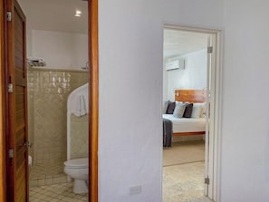 Habitación de hotel con baño, cama y zona de ducha.