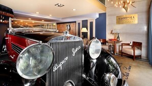 A classic Rolls-Royce in a luxurious room with a chandelier, a sign for 'La Corte di Luna Restaurant', and a bar area with bottles. - Hispanos Siete Suiza (Barcelona)