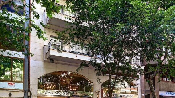 A multi-story building with a ground-level restaurant and an upper-level parking garage. - Hispanos Siete Suiza (Barcelona)