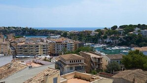 A coastal cityscape with buildings, a marina, and a clear sky. - Estrella Hotel (Manacor)