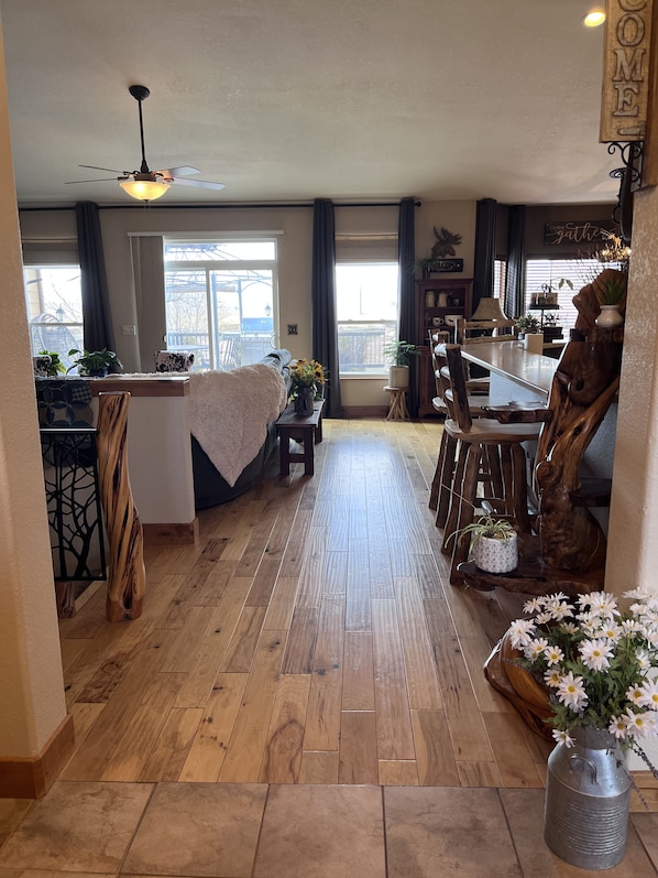 A spacious living area with a wooden floor, a dining table, and a kitchen area with a wooden chair.