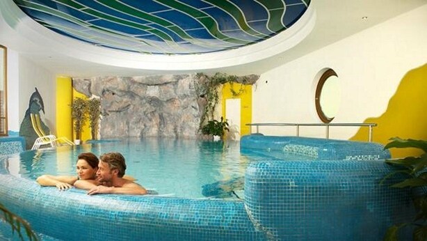 Ein Innenpool mit einer gefliesten Kante, einer Felswand und einer Monddekoration.