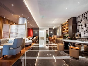 A modern hotel lobby with a marble floor, seating areas, and a bar. - Jinjiang Metropolo Nanjing Confucius temple Center Hotel (Nanjing)