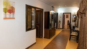 Ein Korridor mit einer Holztür, einem Schrank und einem Gemälde an der Wand.