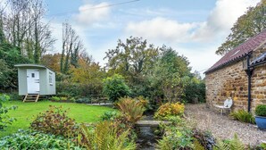 A garden with a small shed, a stone building, and a bench. - 1 bedroom accommodation in Thirlby, near Thirsk (Thirlby, near Thirsk)