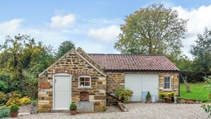 A stone cottage with a gravel driveway, a small garden, and a red-tiled roof. - 1 bedroom accommodation in Thirlby, near Thirsk (Thirlby, near Thirsk)