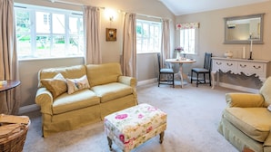 A cozy living room with a sofa, ottoman, and a small table with chairs. - 1 bedroom accommodation in Thirlby, near Thirsk (Thirlby, near Thirsk)