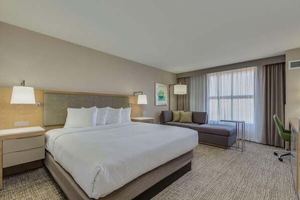 A hotel room with a large bed, a sofa, a desk, and a chair. - Doubletree by Hilton Phoenix Chandler (Chandler)