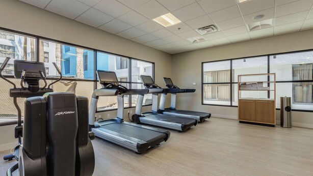 A gym with treadmills, a stationary bike, and a rowing machine.