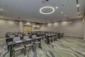 A conference room with rows of tables and chairs, a patterned carpet, and recessed ceiling lighting. - Doubletree by Hilton Phoenix Chandler (Chandler)
