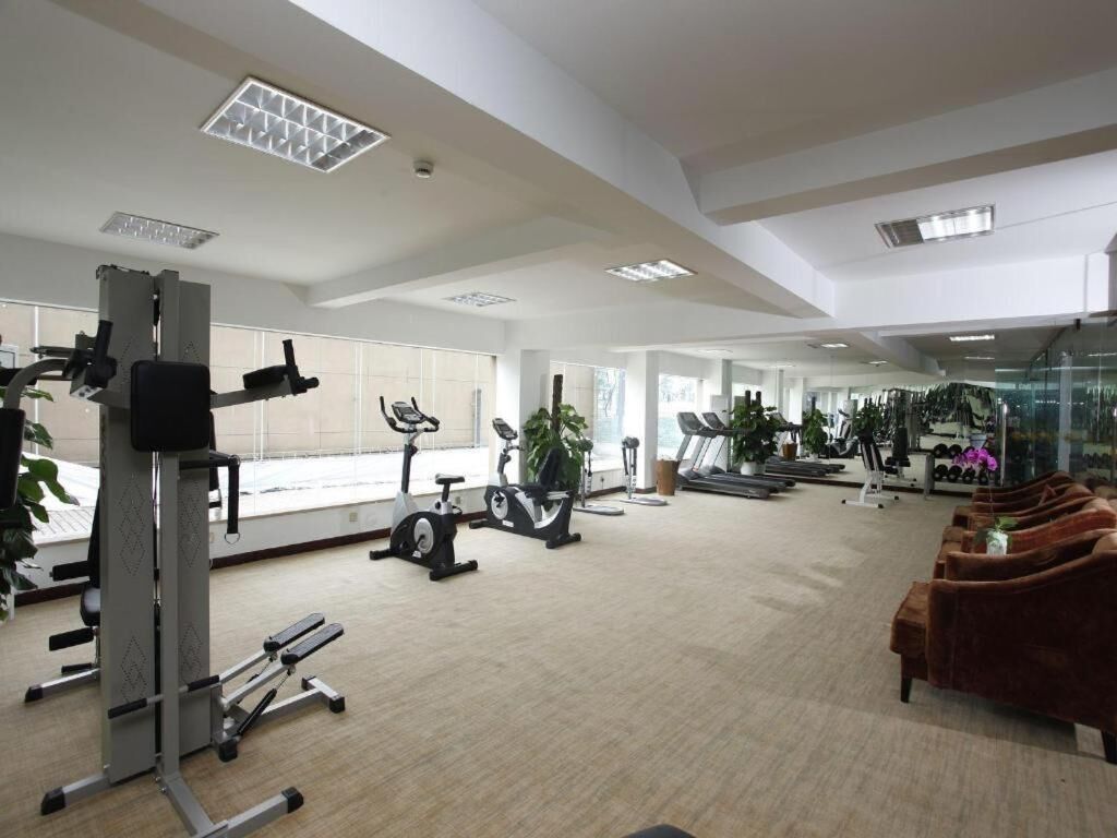 A spacious gym with cardio machines, weight equipment, and a treadmill.