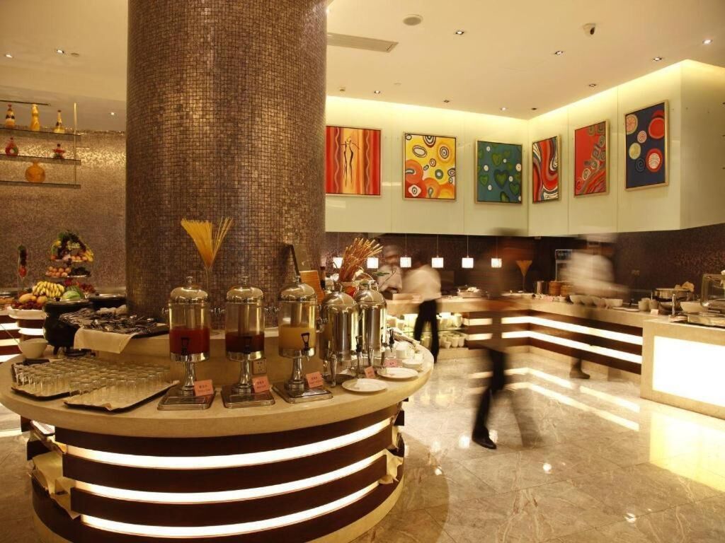 Un hall de hotel con una barra circular en el centro, un pilar grande y obras de arte en las paredes.