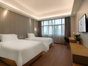 A hotel room with two beds, a desk, a chair, a TV, and a large window with curtains. - Lavande Hotels (Guangzhou)