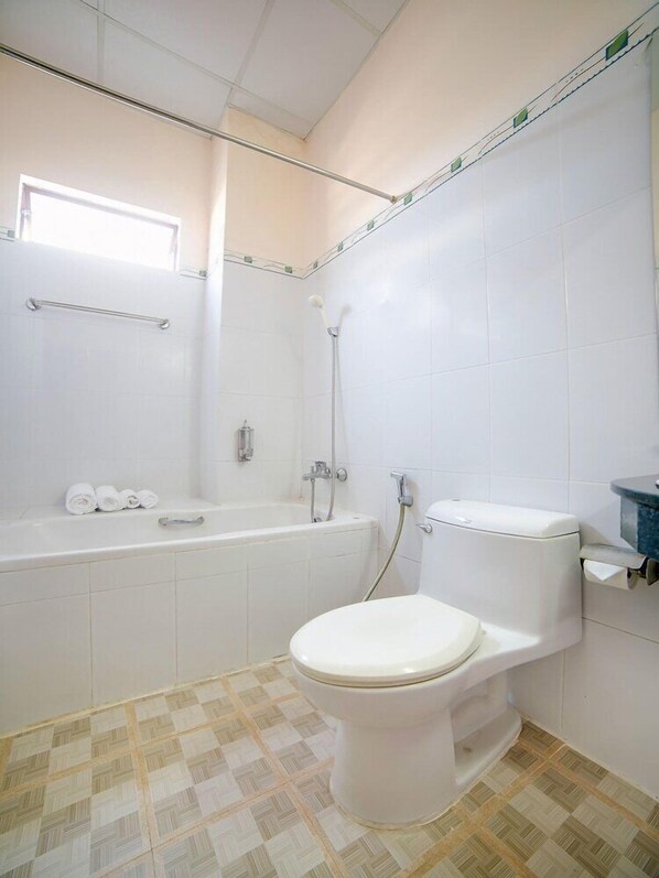 Un baño con inodoro, bañera y ducha.