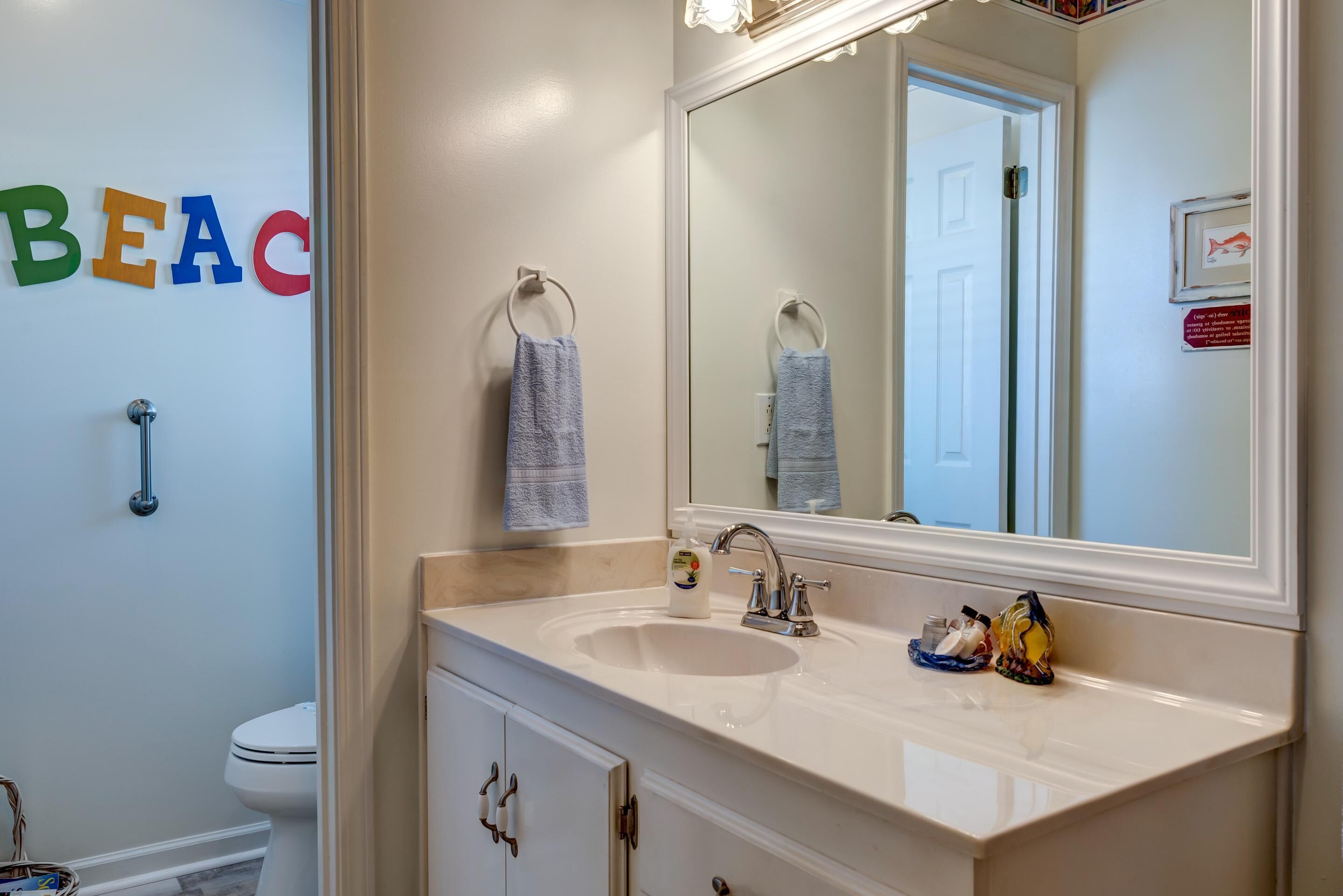 Een badkamer met een wastafel, spiegel en toilet.