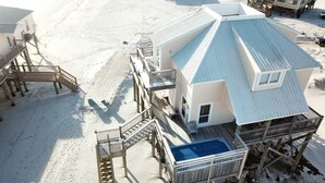 A beach house with a pool, wooden deck, and multiple levels connected by stairs. - Kowabunga - 102 Shell Ct (Dauphin Island)
