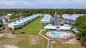 Ein Resort mit mehreren Gebäuden, einem Schwimmbad und einem gepflegten Rasen.