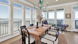 A dining area with a wooden table, chairs, and a chandelier. - Tramarlis - 2254 Sandpiper (Dauphin Island)