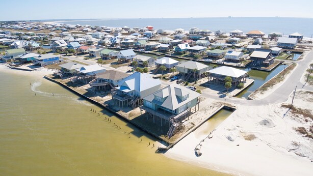 An aerial view of a coastal residential area with houses and a marina. - Tramarlis - 2254 Sandpiper (Dauphin Island)