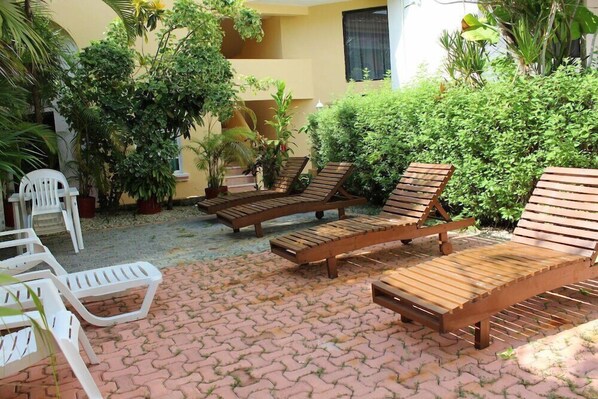 Relax in a serene outdoor space surrounded by lush greenery and comfortable seating.