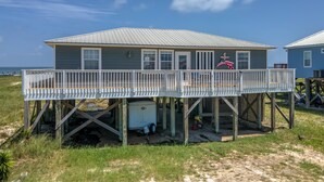 A beach house with a deck, a small shed, and a flag. - Saltaire - 2440 Bienville (Dauphin Island)