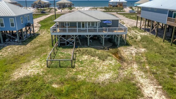 A beachfront property with multiple houses elevated on stilts, featuring outdoor decks and a view of the ocean. - Saltaire - 2440 Bienville (Dauphin Island)