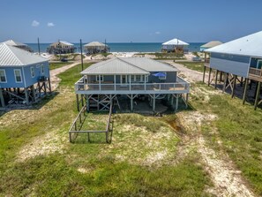 A beachfront property with multiple houses elevated on stilts, featuring outdoor decks and a view of the ocean. - Saltaire - 2440 Bienville (Dauphin Island)