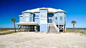 A two-story beach house with a covered porch and a staircase leading to the entrance. - Tidal Wave - 2636 Bienville (Dauphin Island)