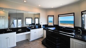 A modern bathroom with a large mirror, a bathtub, and a view of the beach. - Tidal Wave - 2636 Bienville (Dauphin Island)