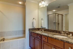 A bathroom with two sinks, a large mirror, and a shower enclosure.