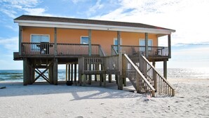 A beach house with a wooden deck, multiple balconies, and a view of the ocean. - Sun Spot - 104 Vargas Ct (Dauphin Island)