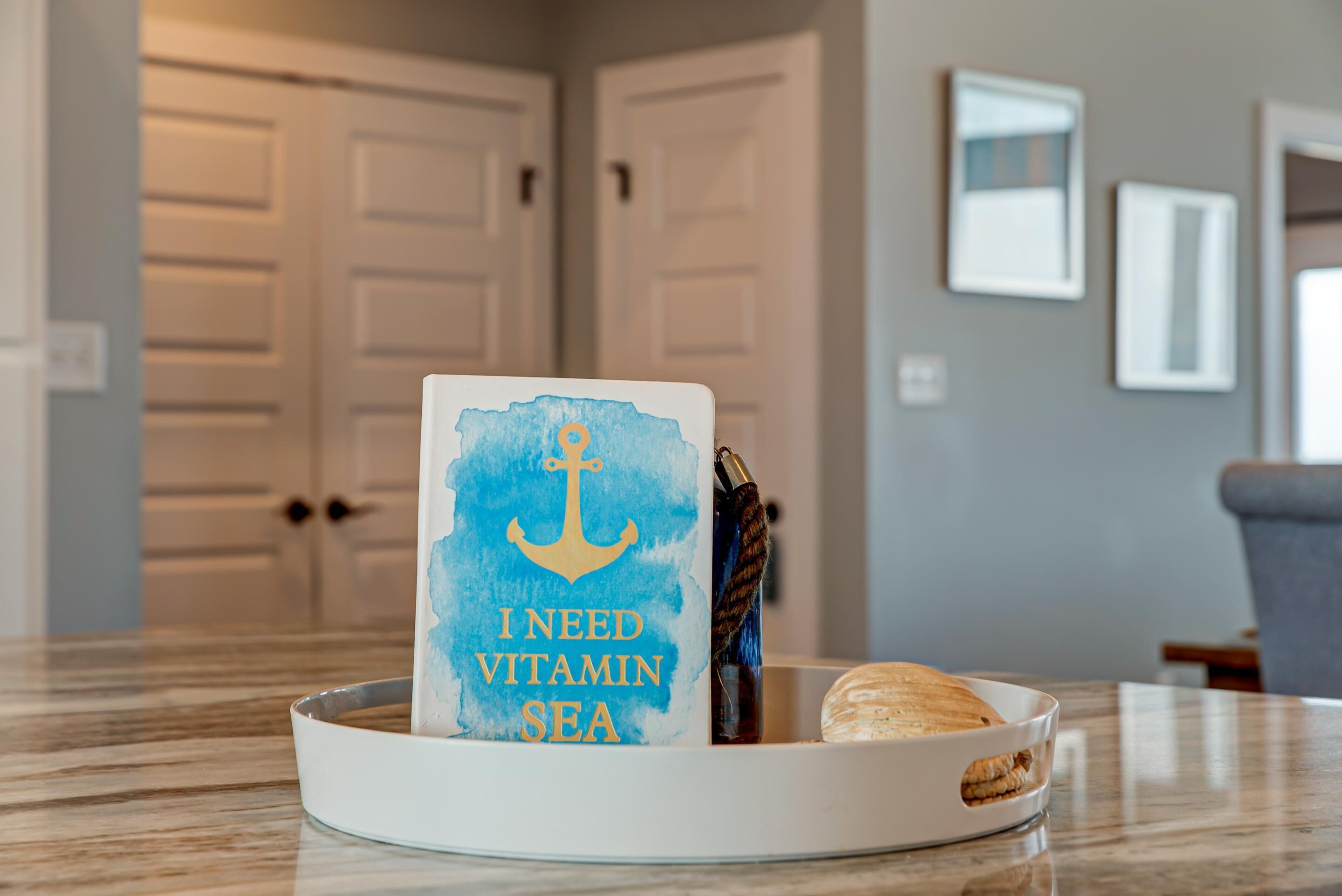 A card with an anchor and text in a tray on a marble countertop.
