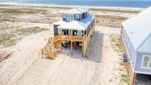 A beach house with a deck, a covered porch, and a view of the ocean. - Endless Possibilities-1809 Bie (Dauphin Island)