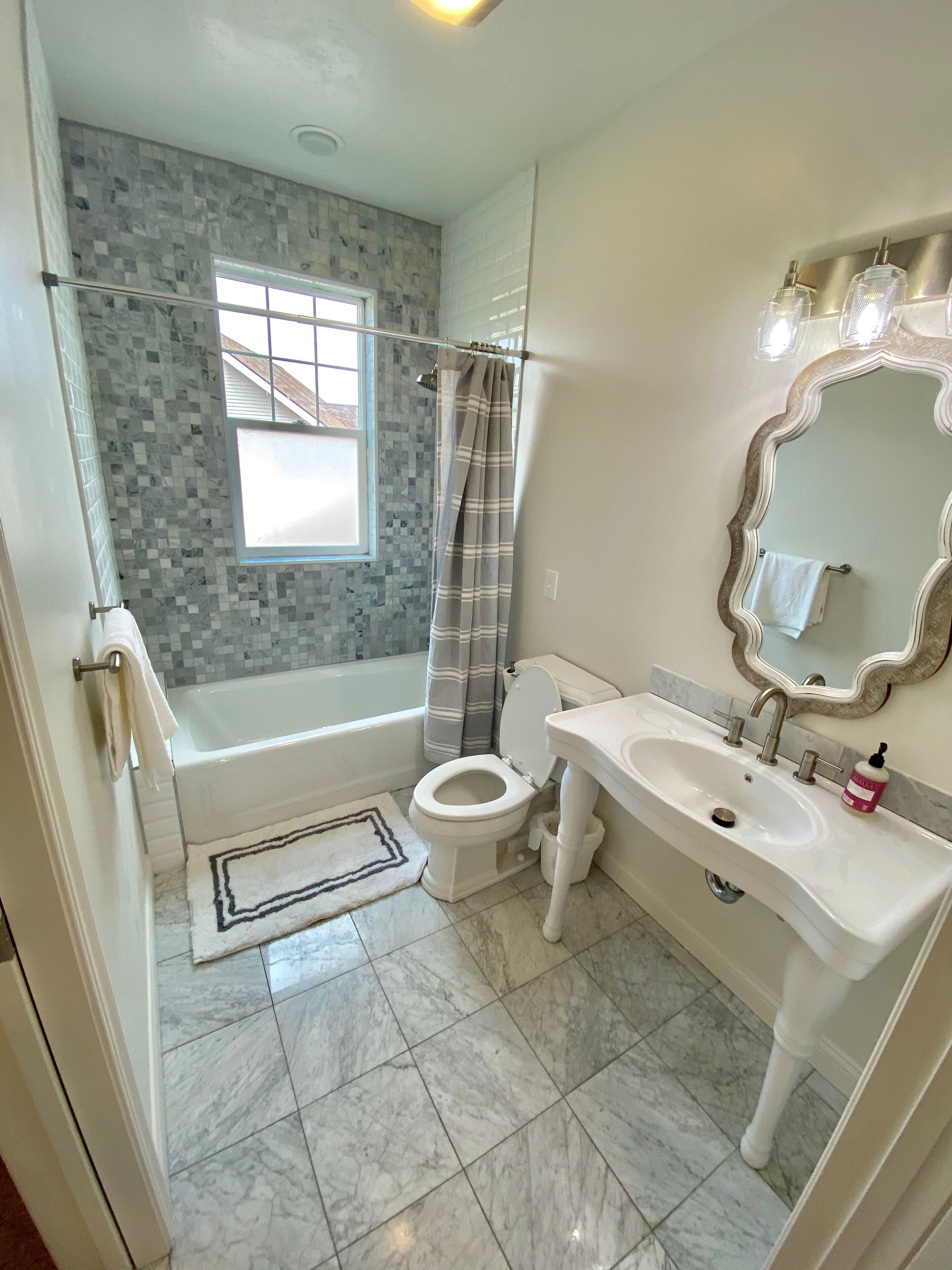 A bathroom with a bathtub, toilet, sink, and a shower curtain.