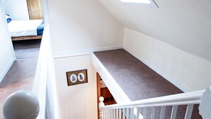 A staircase with a white railing and carpeted steps leading to a landing. - Comfy 3-bedroom Cottage in Newtonmore, Cairngorms (Newtonmore)