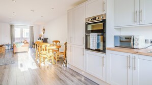 A modern kitchen with white cabinets, a built-in oven, and a microwave. - 3 bedroom accommodation in St Bees, near Whitehaven (St Bees, near Whitehaven)