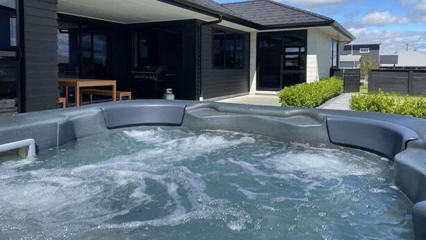 Ein modernes Haus mit Whirlpool im Garten.