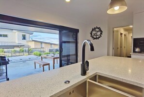 A modern kitchen with a large window, a built-in sink, and a countertop.