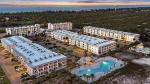 A multi-story hotel with a swimming pool, parking areas, and a view of the ocean. - Gulf Shores Plantation-East 3210 (Gulf Shores)