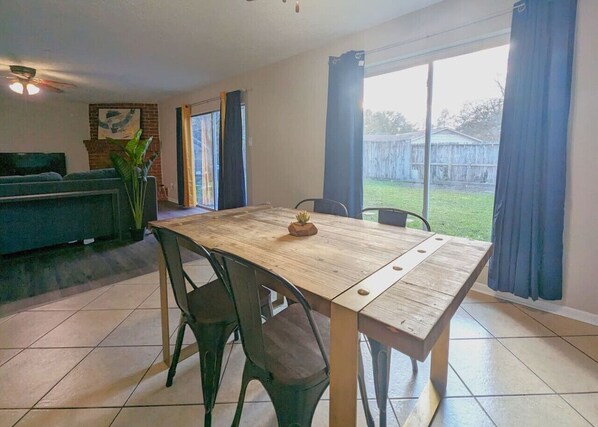 A dining area with a wooden table, four chairs, and a small plant on the table. - Quiet, Spacious, Pet-Friendly (Humble)