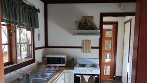 A kitchen with a stove, sink, and microwave.