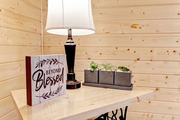 Una pared de madera con una lámpara blanca, un letrero que dice "Beyond Blessed" y tres macetas con suculentas.