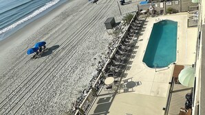 A beachside hotel with a pool, sun loungers, and a view of the ocean. - Horizon East 704 - Oceanfront in Garden City Beach, SC (Garden City)