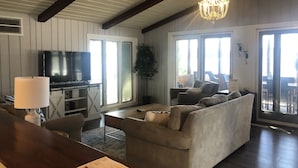 Ein Wohnzimmer mit einer Couch, Fernseher und einer Kandelaber.