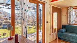 A wooden interior with a sofa, a lamp, and a painting on the wall. - Charming Tiny House “Loft Süd” with Mountain View, Wi-Fi, Terrace and Garden (Unterammergau)