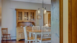 A kitchen with wooden cabinets, a dining table with chairs, and a chandelier. - Enjoy swimming/boating in the lake, Fall Foliage, Wine trail, Skiing and Hiking (Canandaigua)