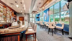 Un área de bar con mostrador, asientos y vistas al exterior.