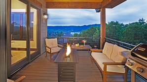 Une terrasse en bois dotée d’un foyer extérieur, d’un espace salon extérieur et d’un barbecue.
